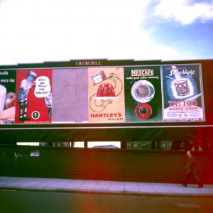 Advertising hoarding c1955/6 with several ads on it including Patrick Tilley
